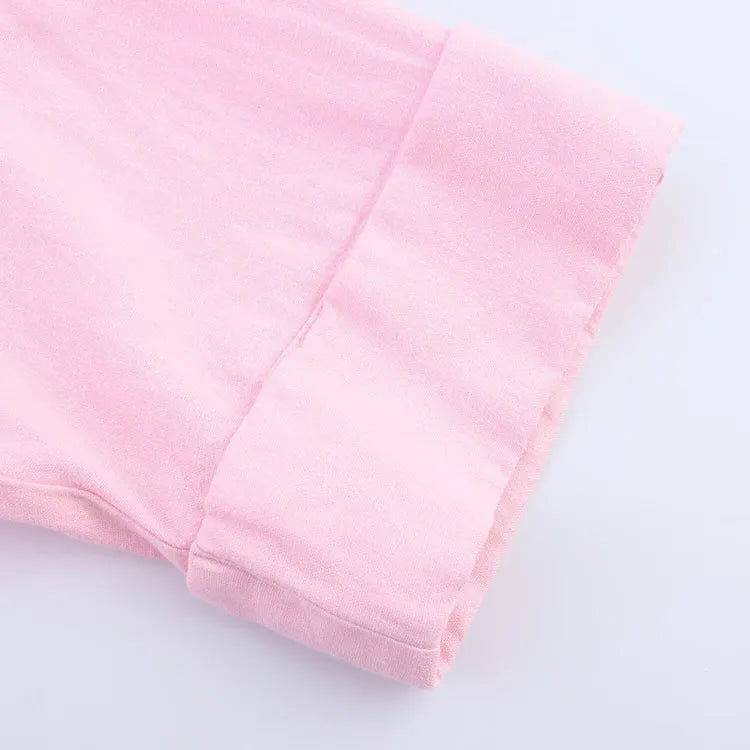 Close-up of the rolled cuff of a pink asymmetrical linen shirt with wide sleeves.
