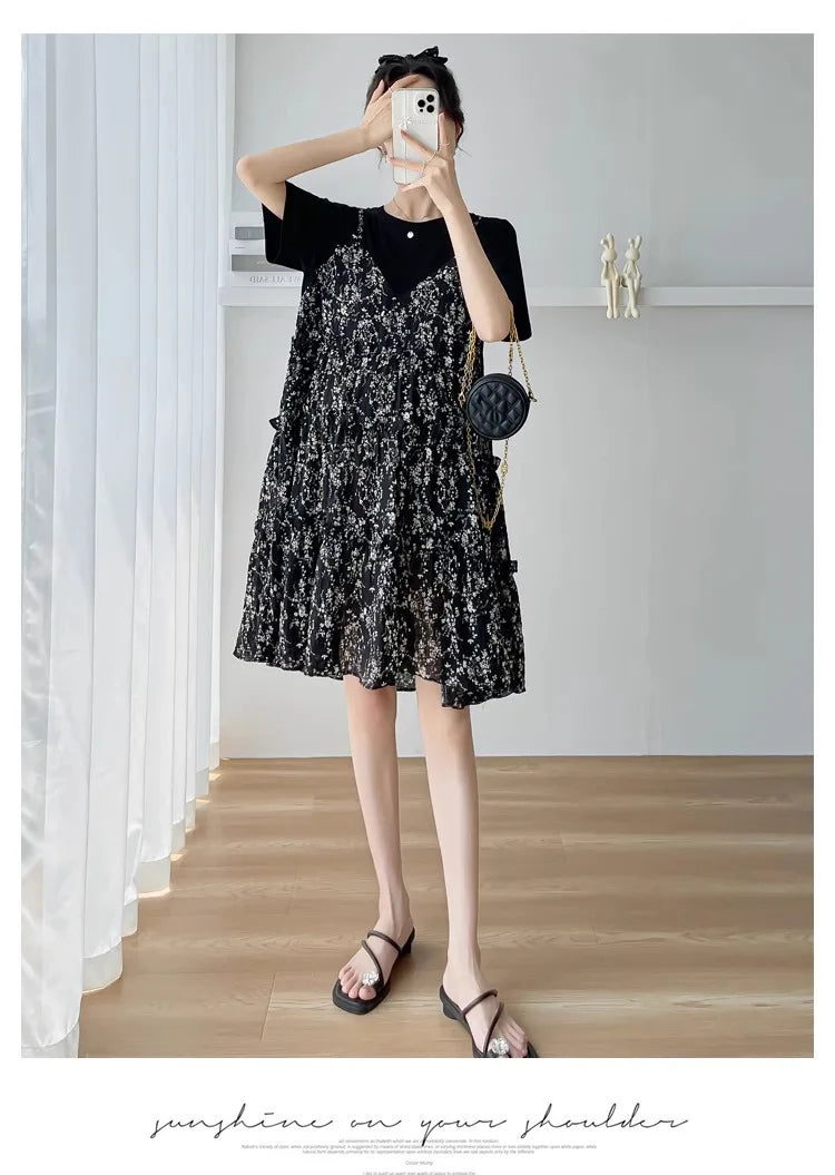 Stylish woman wearing a black floral sundress with a black T-shirt and sandals, perfect for summer outings.