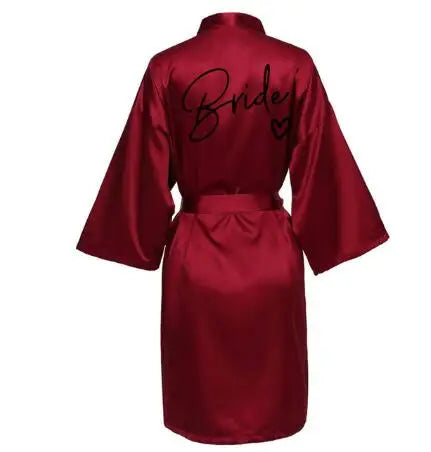 Back view of a satin burgundy robe with the word 'Bride' printed in elegant script.