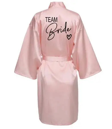 Back view of the pink Team Bride satin robe with stylish black lettering, perfect for bridal parties.