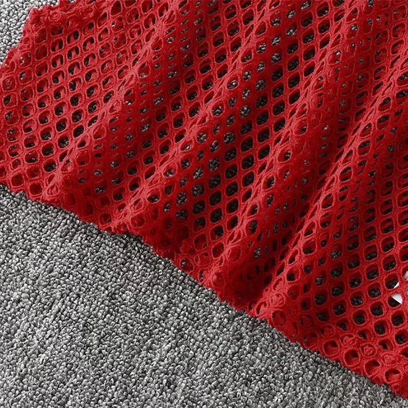 Close-up of red mesh fabric with hollow-out design, showcasing its breathable and stylish texture for summer wear.