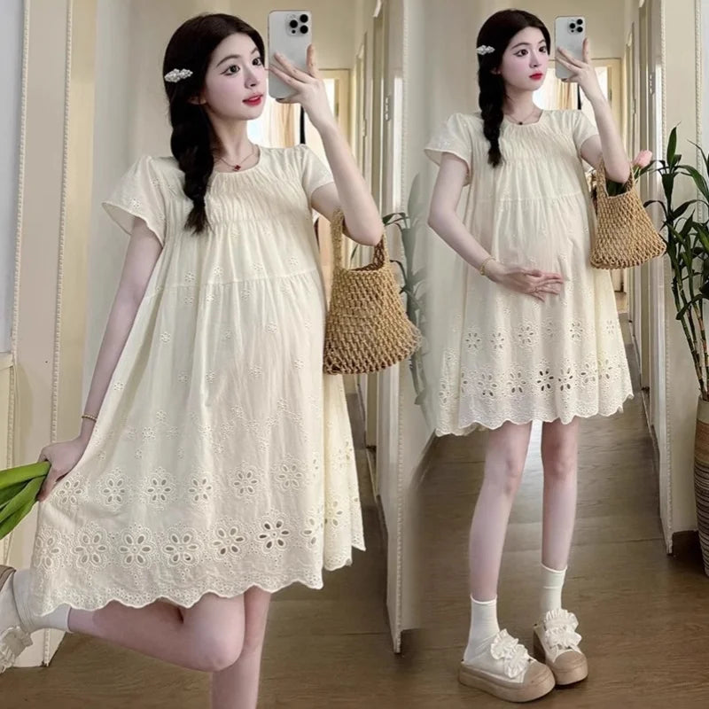 A-line cotton maternity dress in hollowed out style, featuring a light color and knee-length cut, perfect for summer.