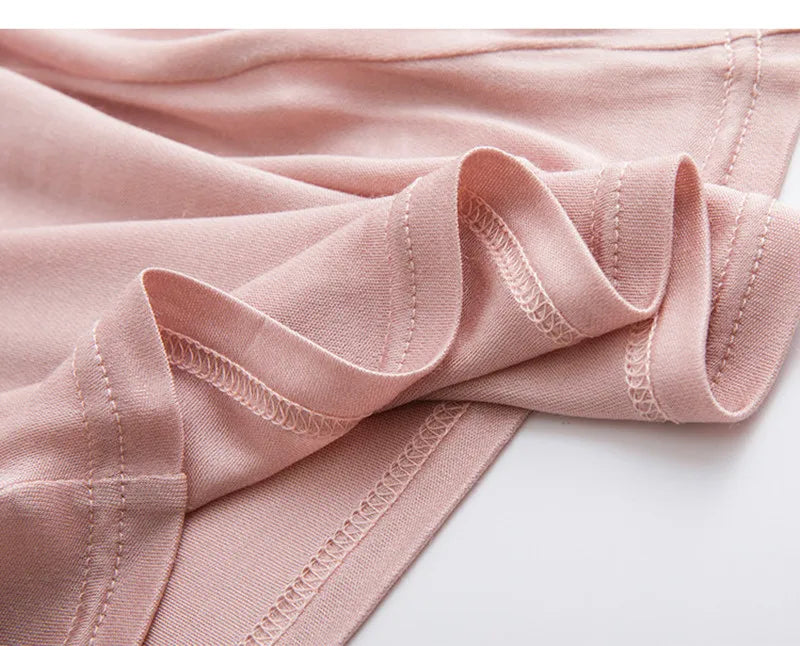Close-up of soft pink silk fabric showcasing delicate lace details and smooth texture for LuxeLace™ camisole.
