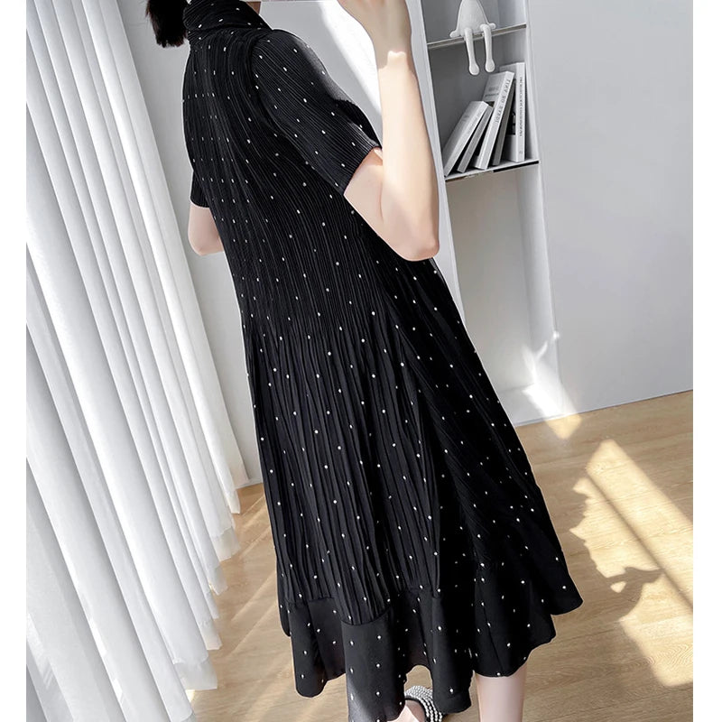 Black polka dot maternity dress with short sleeves and a high waist, perfect for summer style.