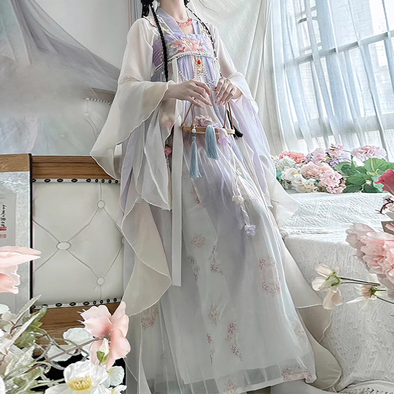 Woman wearing a Vintage Chinese Style Hanfu Dress with delicate floral patterns, surrounded by flowers in a bright room.