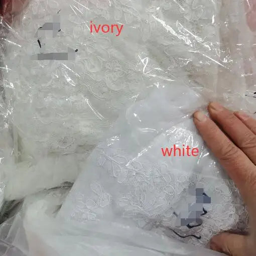 Ivory and white lace fabrics in packaging, suitable for creating bridal wraps and wedding apparel.