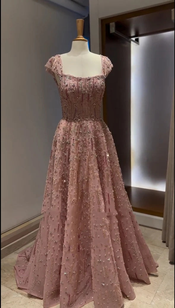 Fully crystal mermaid wedding gown in soft pink, embellished with beading and sequins, featuring a square collar and a flowing skirt.