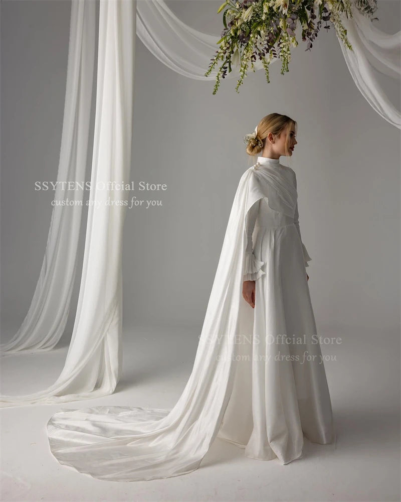 Elegant Muslim satin wedding dress with high neck, long sleeves, and trailing fabric, adorned with pearls.