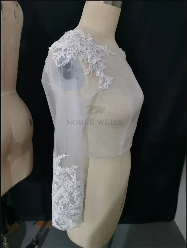 Lace bridal bolero with long sleeve appliques, elegant wrap by Noble Weiss, perfect for weddings and special occasions.