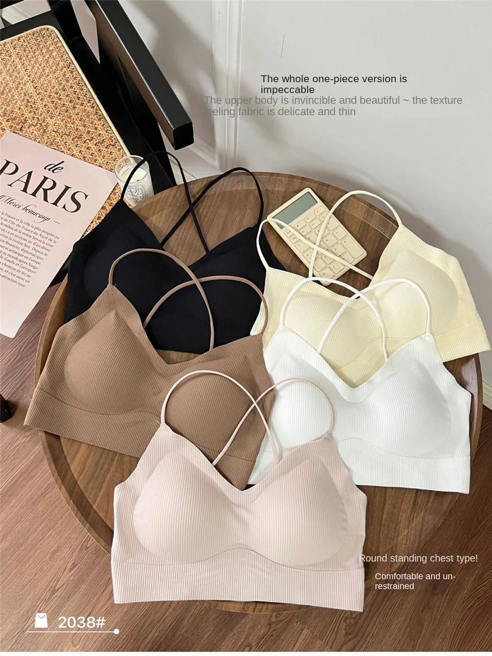 Assorted colors of CrossForm™ padded backless tank tops displayed on a wooden table, featuring soft fabric and trendy design.