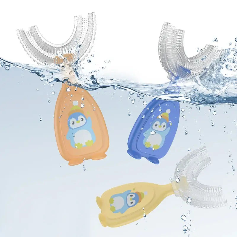 Three penguin-themed baby toothbrushes submerged in water, showcasing vibrant colors and soft silicone design for toddlers.
