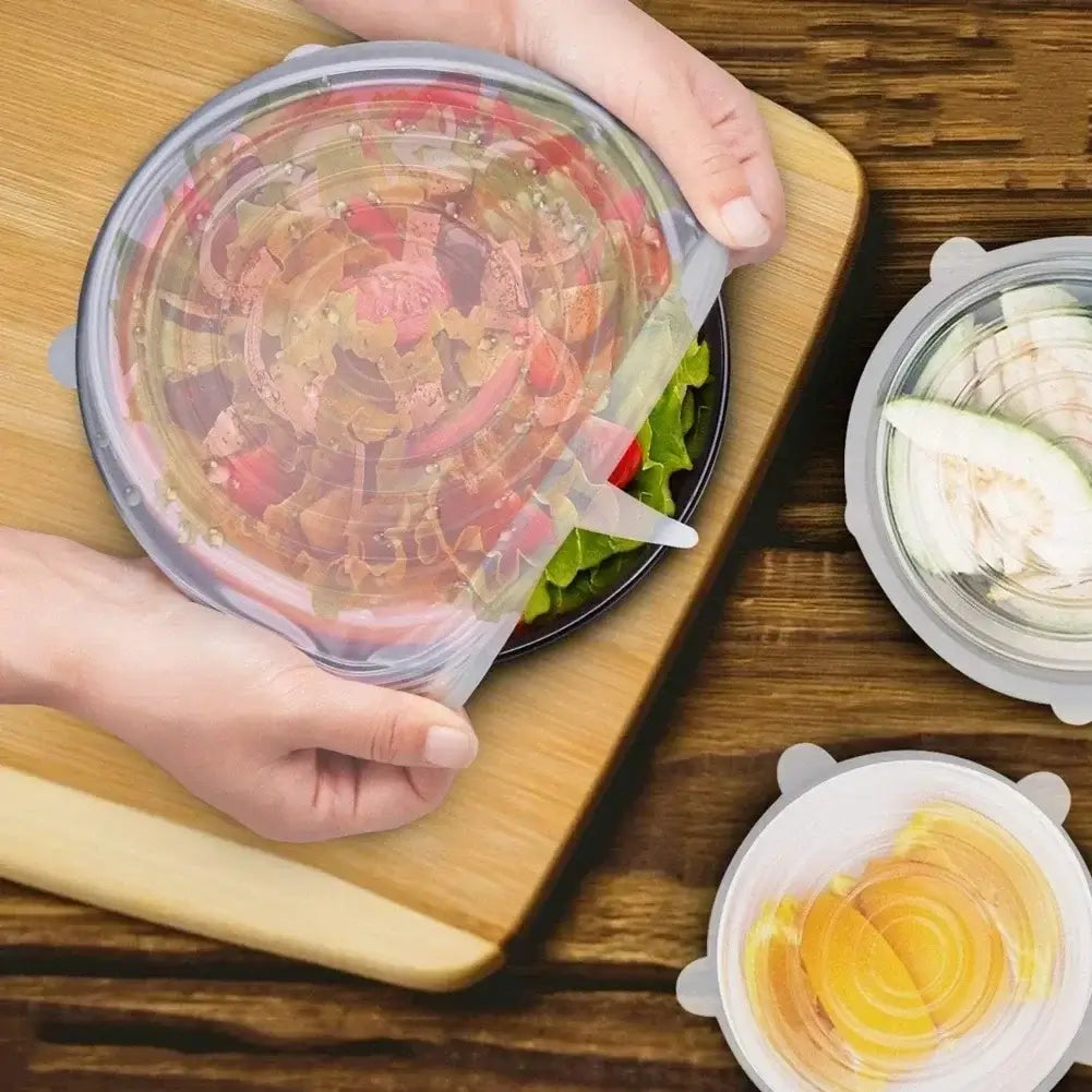 Hands applying adjustable silicone food cover on a bowl of salad, showcasing airtight food preservation.