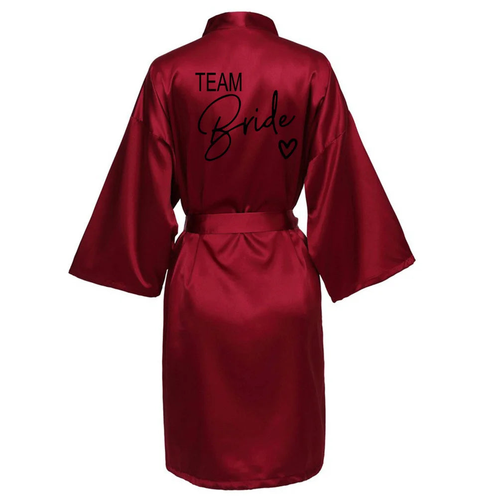 Team Bride satin robe in burgundy, featuring elegant black lettering and a stylish kimono design.