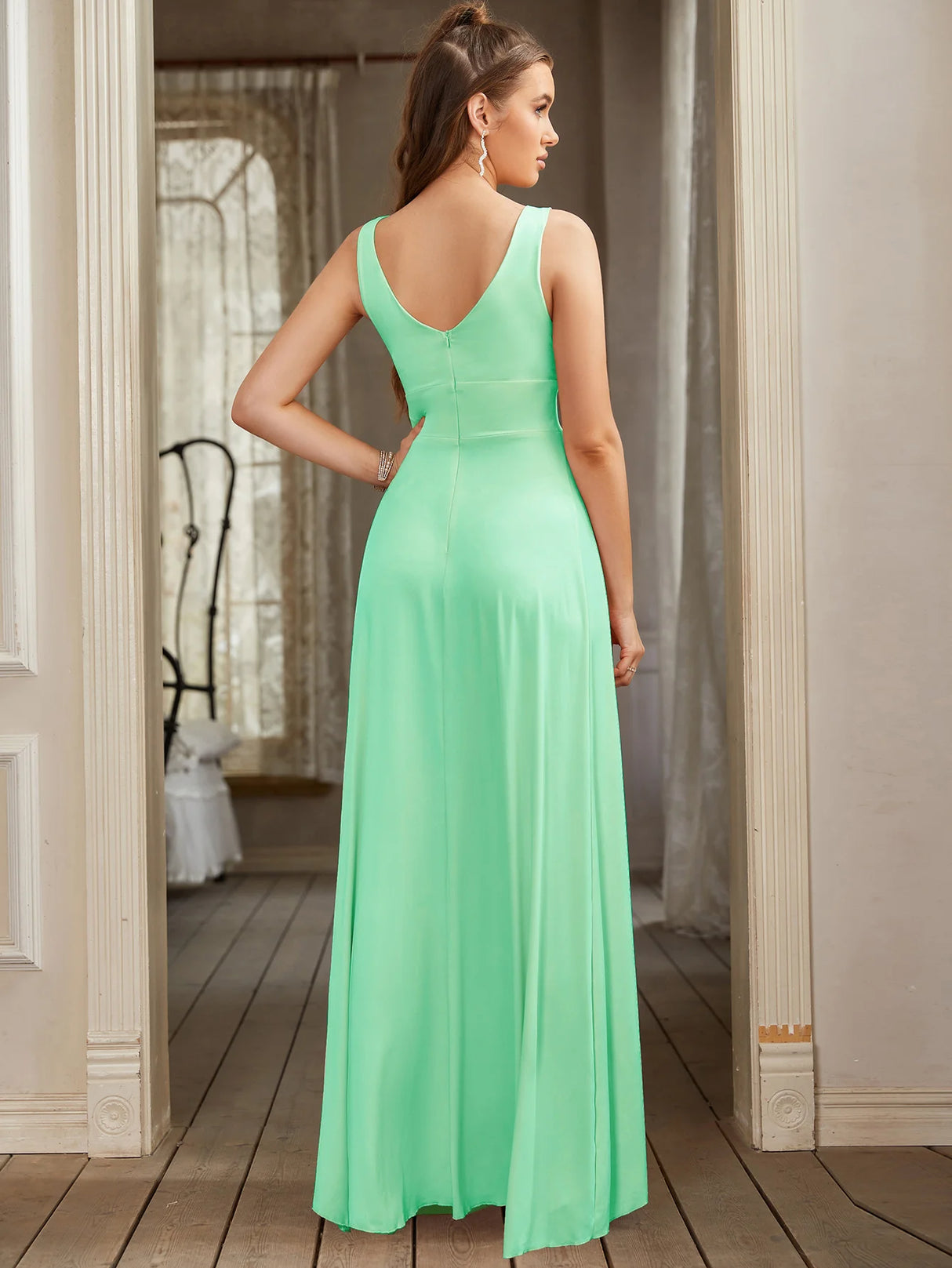 Back view of a floor-length V-neck bridesmaid dress in mint green, showcasing its elegant silhouette and sleeveless design.