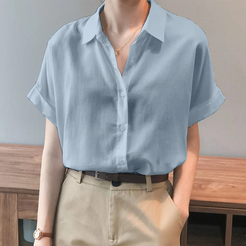 Light blue oversized summer blouse with button-down closure and turn-down collar, styled for a relaxed fit.
