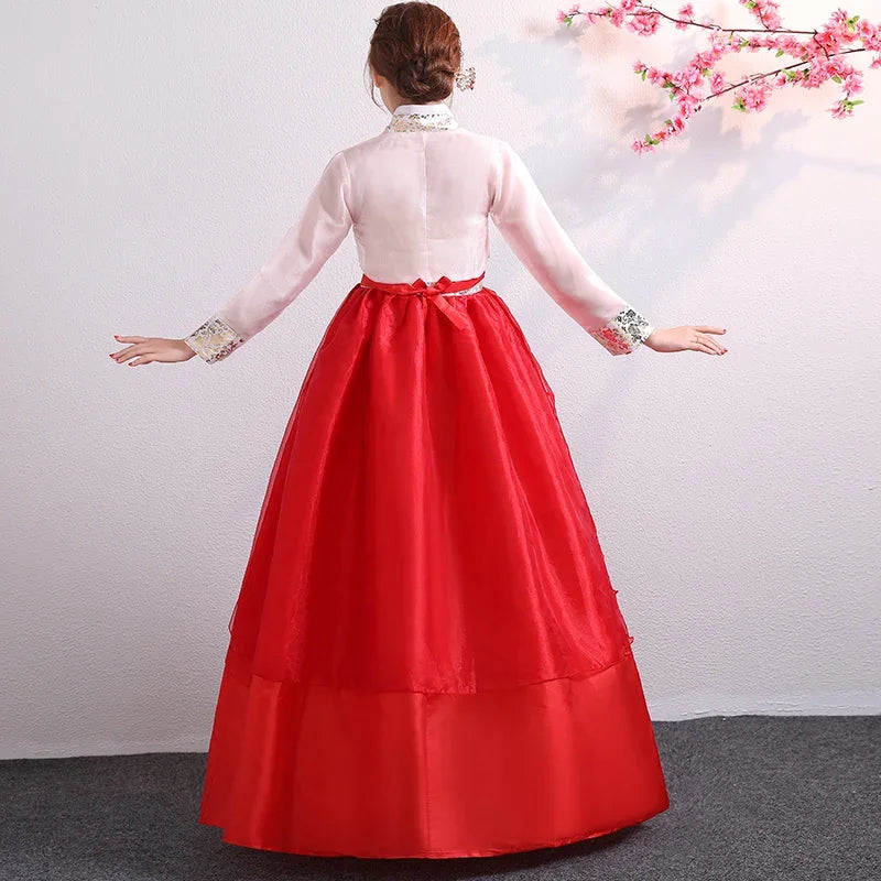 Back view of a woman in a traditional red Korean Hanbok, featuring full skirt and elegant design for special occasions.