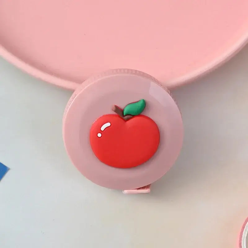 Cute round measuring tape with a red apple design, perfect for kids' crafts and home use.