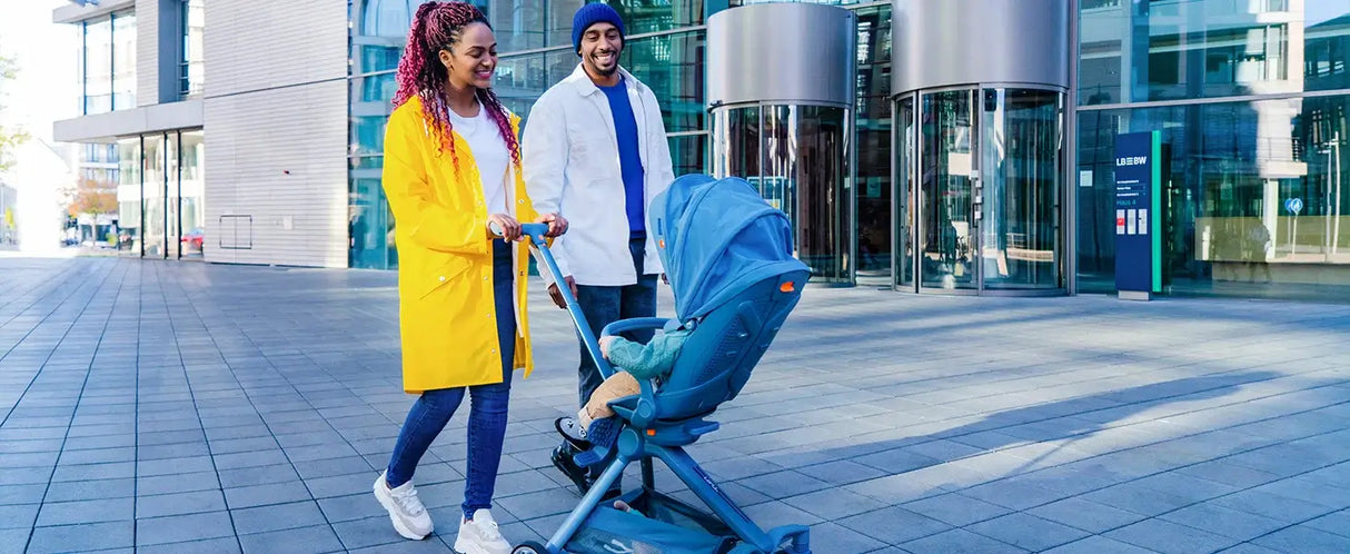 Happy family using the Baby Travel Stroller Mini ELF 2 Lightweight on a sunny day in an urban setting.