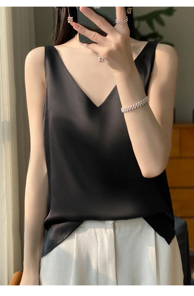 Black satin V-neck camisole worn with light trousers, perfect for summer and office style.