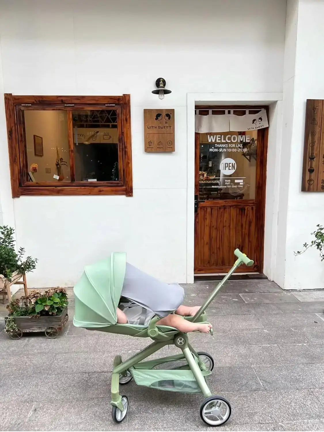 Lightweight Baby Travel Stroller Mini ELF 2 parked outside a shop, perfect for infants and toddlers, foldable design.