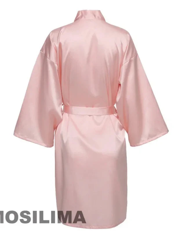 Back view of a pink satin kimono robe with wide sleeves and a tied waist, perfect for bridesmaids.