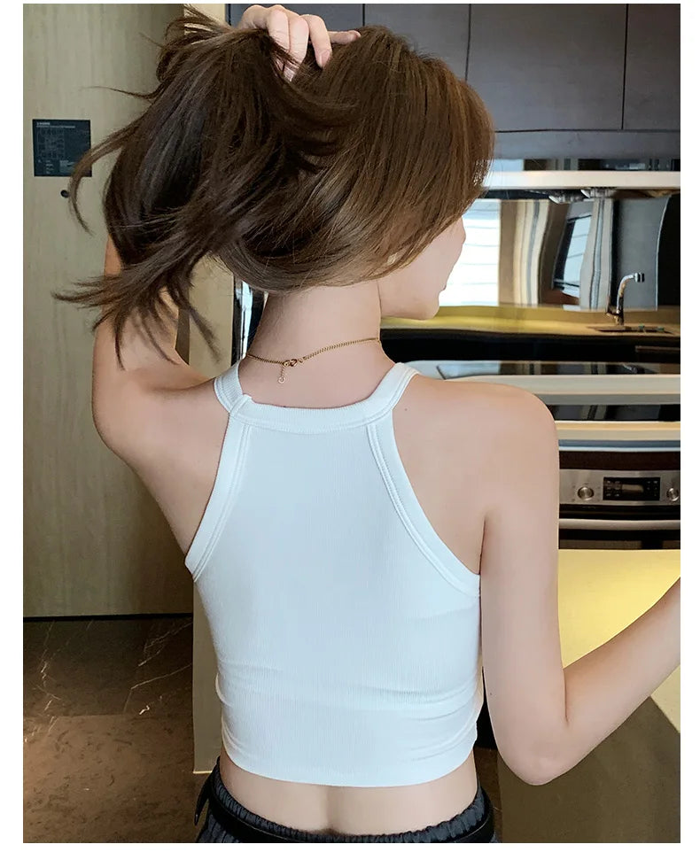 Woman wearing a white knitted back camisole, showcasing soft cotton comfort and casual style.