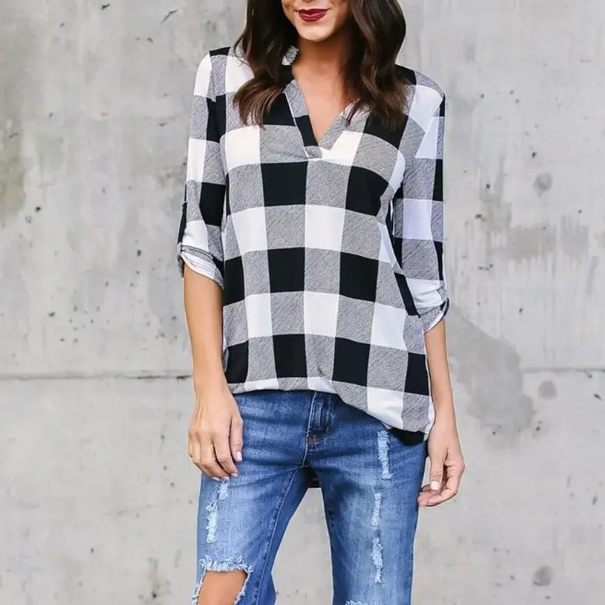 Woman in plaid V-neck short sleeve top paired with distressed jeans, perfect for casual beach style in spring/summer.