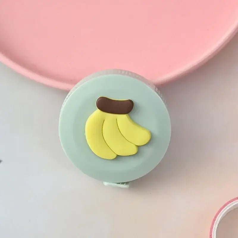 Cute banana-shaped tape measure with a green casing, perfect for home or school use, creatively designed and colorful.