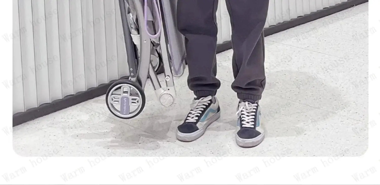 Foldable lightweight children's stroller being carried by a person in casual attire, ready for travel.