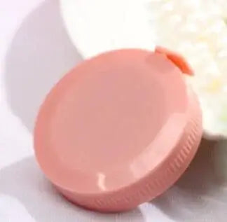 Pink round plastic container lid on a white background, perfect for cosmetics or small items.