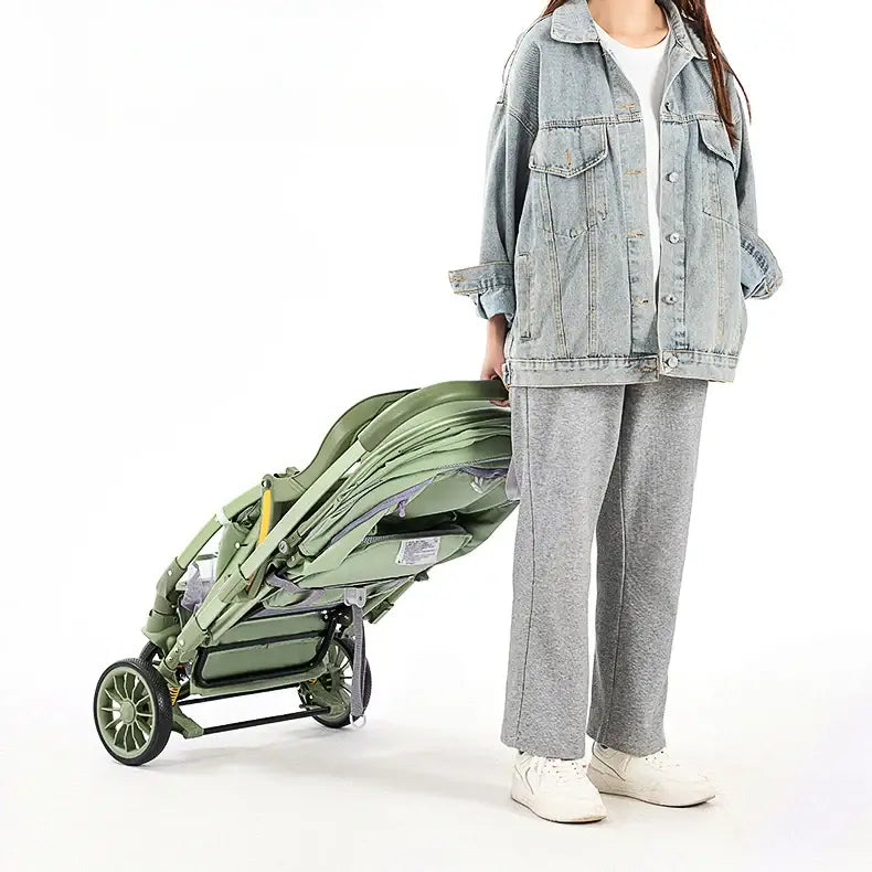 Woman in casual wear carrying a bi-directional high landscape baby stroller, showcasing its portable design.