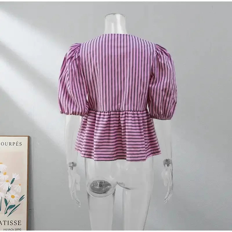 Back view of BowChic™ Stripe Lace-Up Blouse, featuring puff sleeves and a striped design, ideal for vintage style.