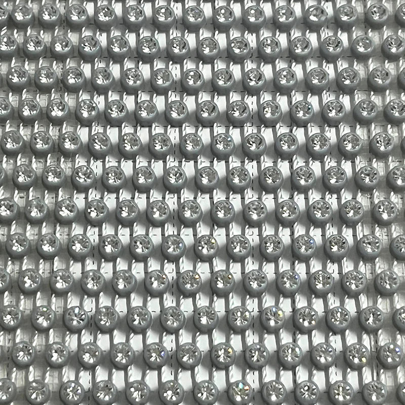 Close-up of shimmering rhinestones in a pattern, ideal for glamorous clothing and accessories.