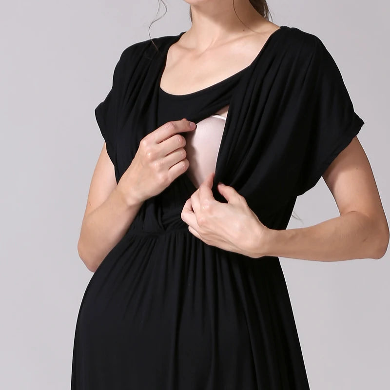 Close-up of a woman showcasing the nursing feature of a black maternity dress by Emotion Moms.