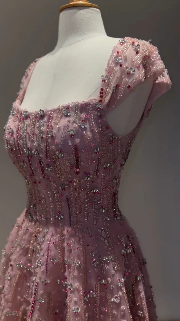 Close-up of a pink glitter crystal mermaid wedding gown with beaded detailing and cap sleeves.