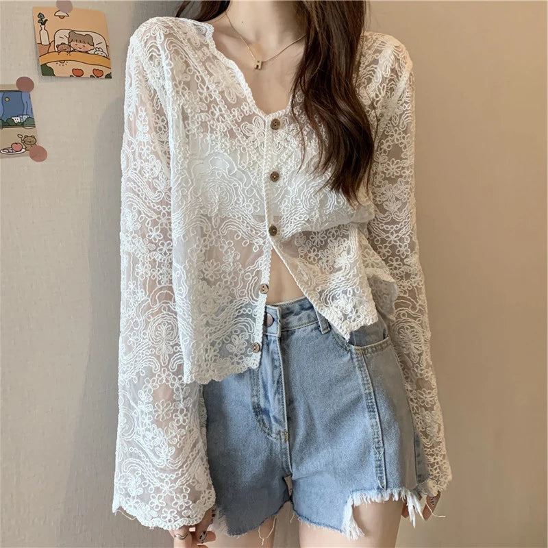 SheerCharm™ lace sun shirt with long sleeves and buttons worn over denim shorts, perfect for summer style.