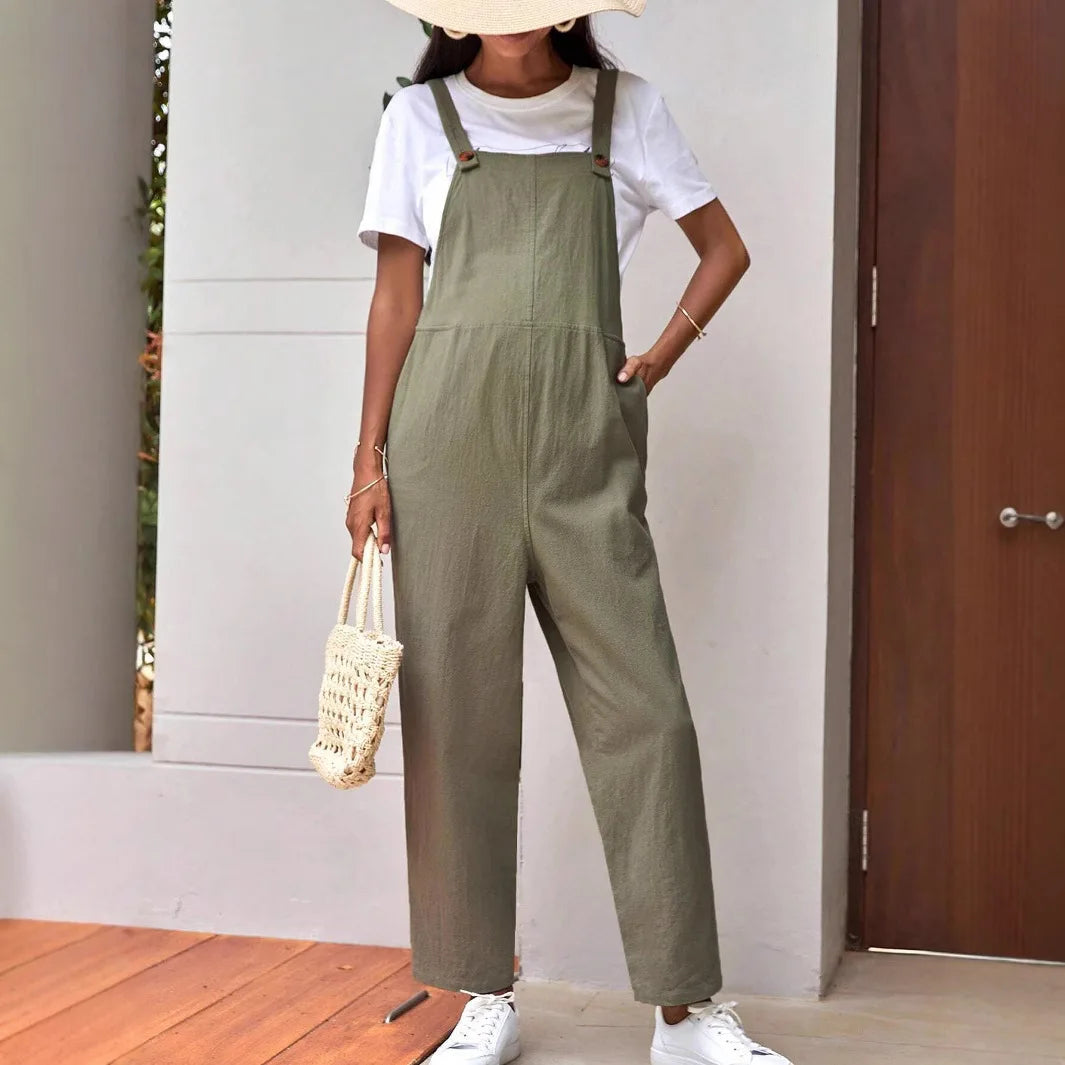 Stylish woman wearing adjustable maternity overalls in olive green, paired with a white T-shirt and accessories.