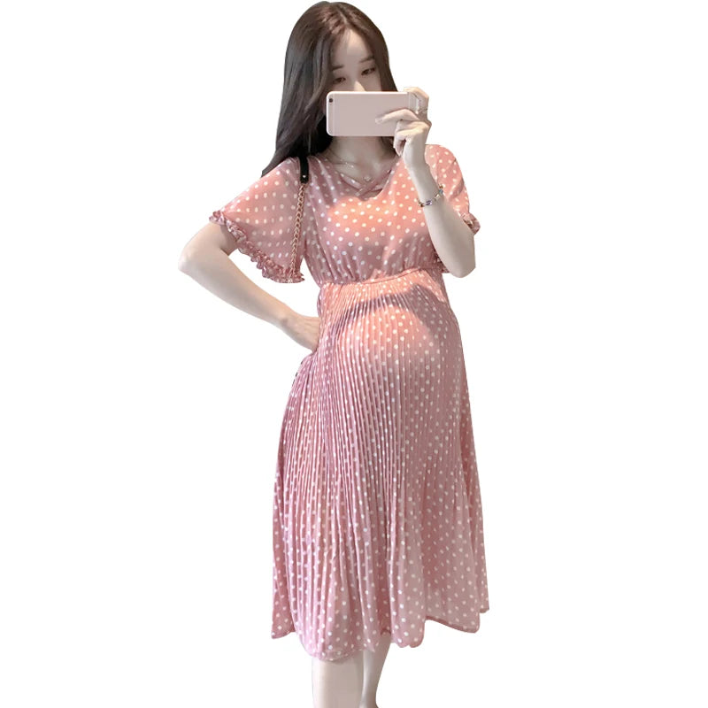 Chiffon polka dot maternity dress in pink, featuring a boat neck and pleated design, ideal for summer wear.