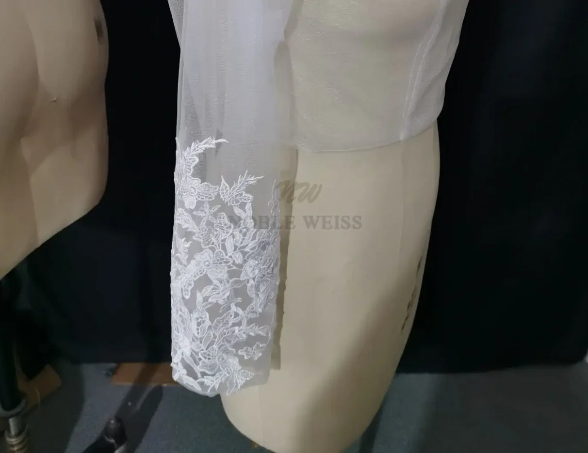 Lace Bridal Bolero featuring long sleeve appliques on a dress form, showcasing elegant embroidery details.