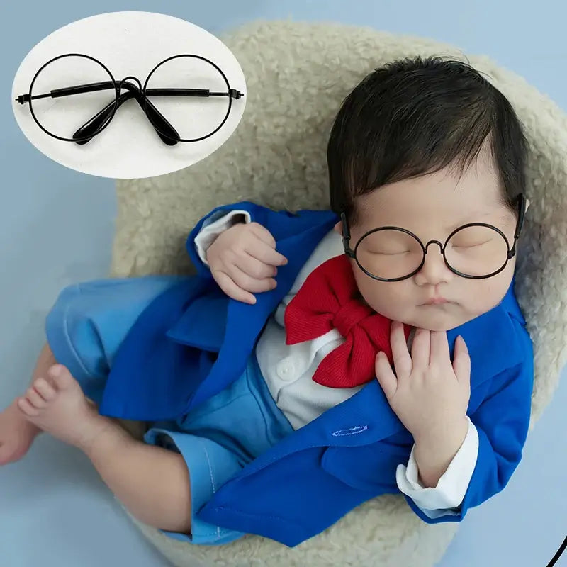 Newborn wearing colorful round glasses in a blue suit with red bow tie, perfect for photography accessories.