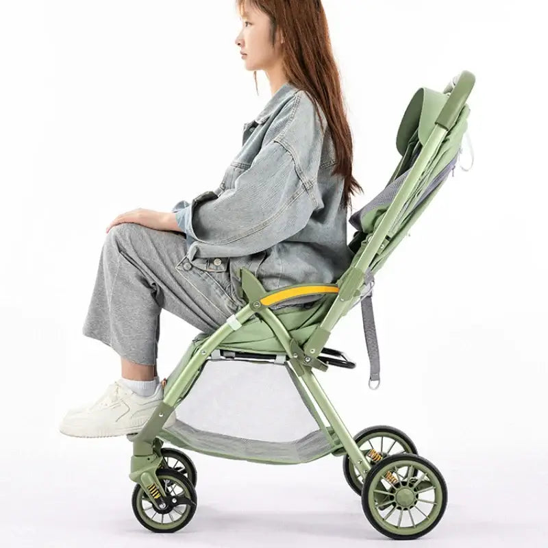 Bi-directional high landscape baby stroller in green, shown from the side with lightweight design and foldable feature.