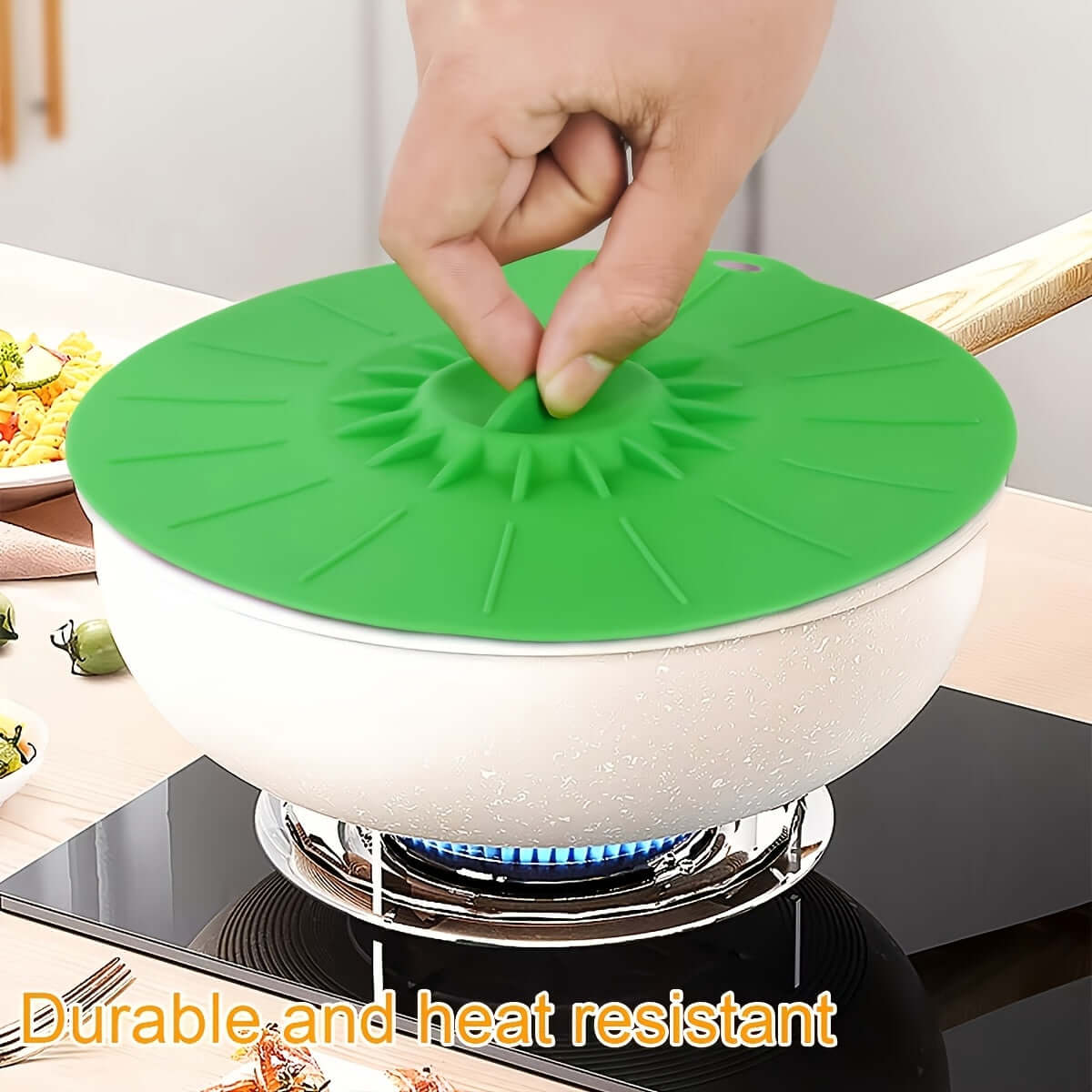 Green silicone bowl lid placed on a pot, showcasing its heat resistance and durable design in kitchen setting.