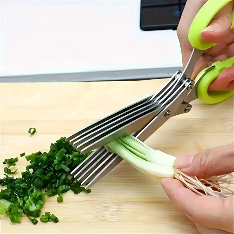Durable stainless steel kitchen scissors cutting green onions on a wooden board, ideal for food preparation.