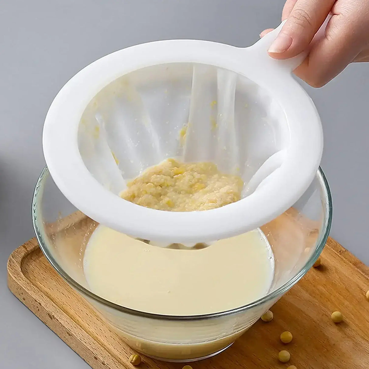 Ultra Fine Nylon Filter Mesh Strainer in use, straining solid ingredients from liquid in a glass bowl.