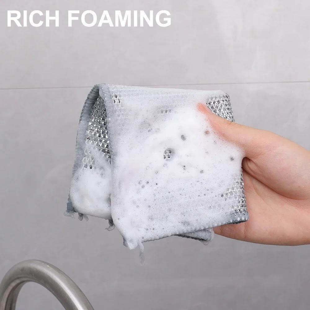 Foamy non-stick dishwashing cloth in hand, showcasing its rich foaming ability for effective cleaning in kitchen.