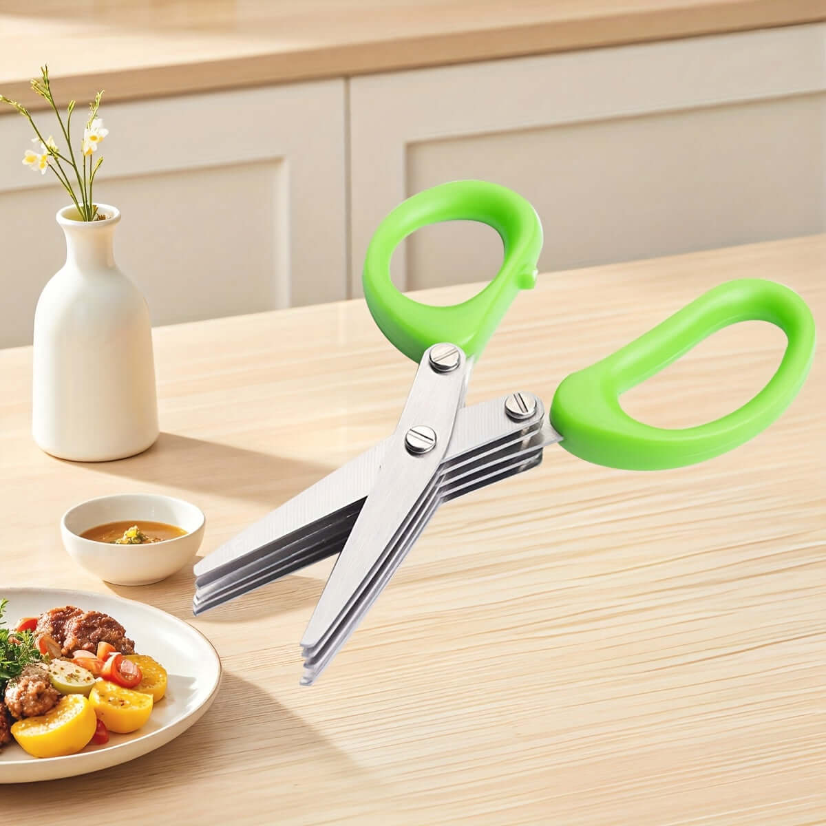 Durable stainless steel kitchen scissors with green handles on a wooden table, ideal for food preparation.
