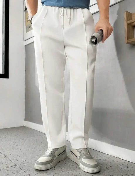 Men's casual white pants with elastic waistband, paired with a blue top and stylish sneakers, perfect for relaxed outings.