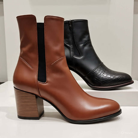 Stylish women's ankle boots featuring a brown leather pair and a black crocodile-textured bootie, perfect for any outfit.