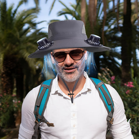 Man wearing a men's adjustable fan hat with sunglasses, surrounded by palm trees, showcasing a stylish summer look.