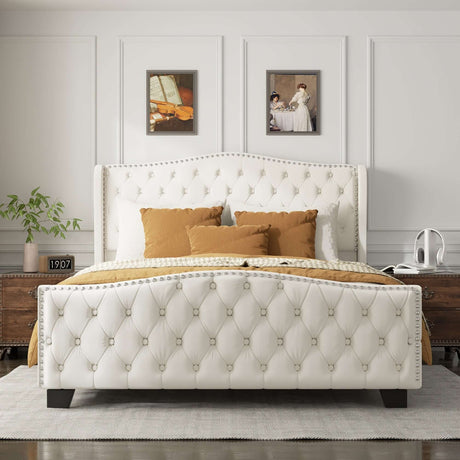 Contemporary bed frame with tufted white upholstery, decorative buttons, and wooden legs, styled with yellow and brown pillows.